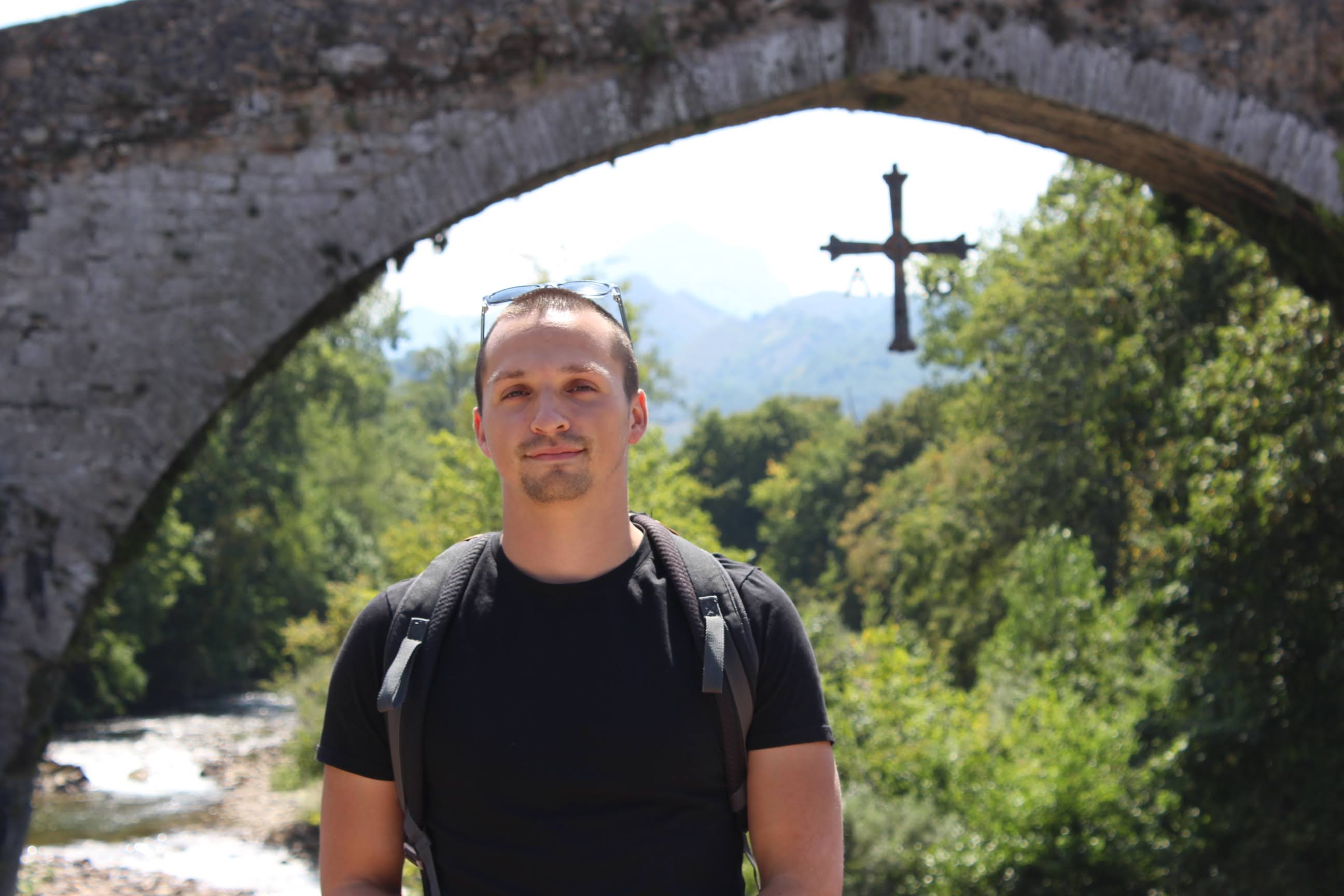Braxton Massengale outdoors beneath a stone bridge
